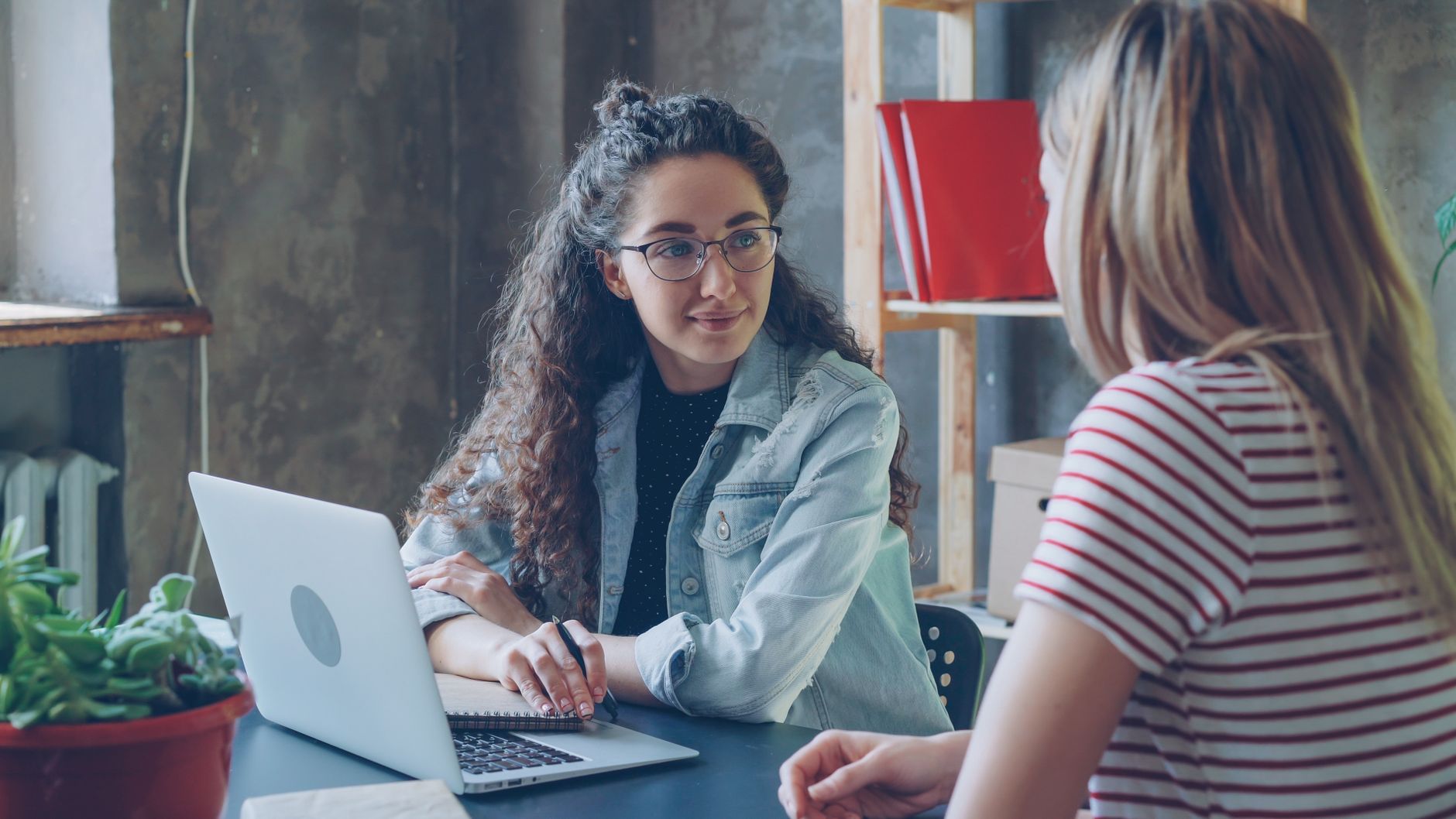 Two women having a casual business meeting in a modern office setting.