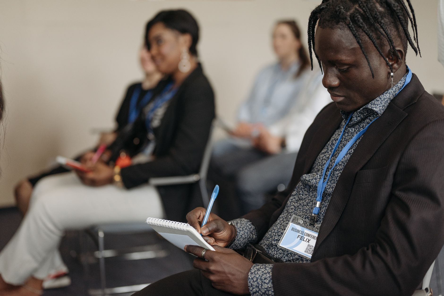 A diverse group of adults attentively participating in a business workshop, taking notes and engaging.