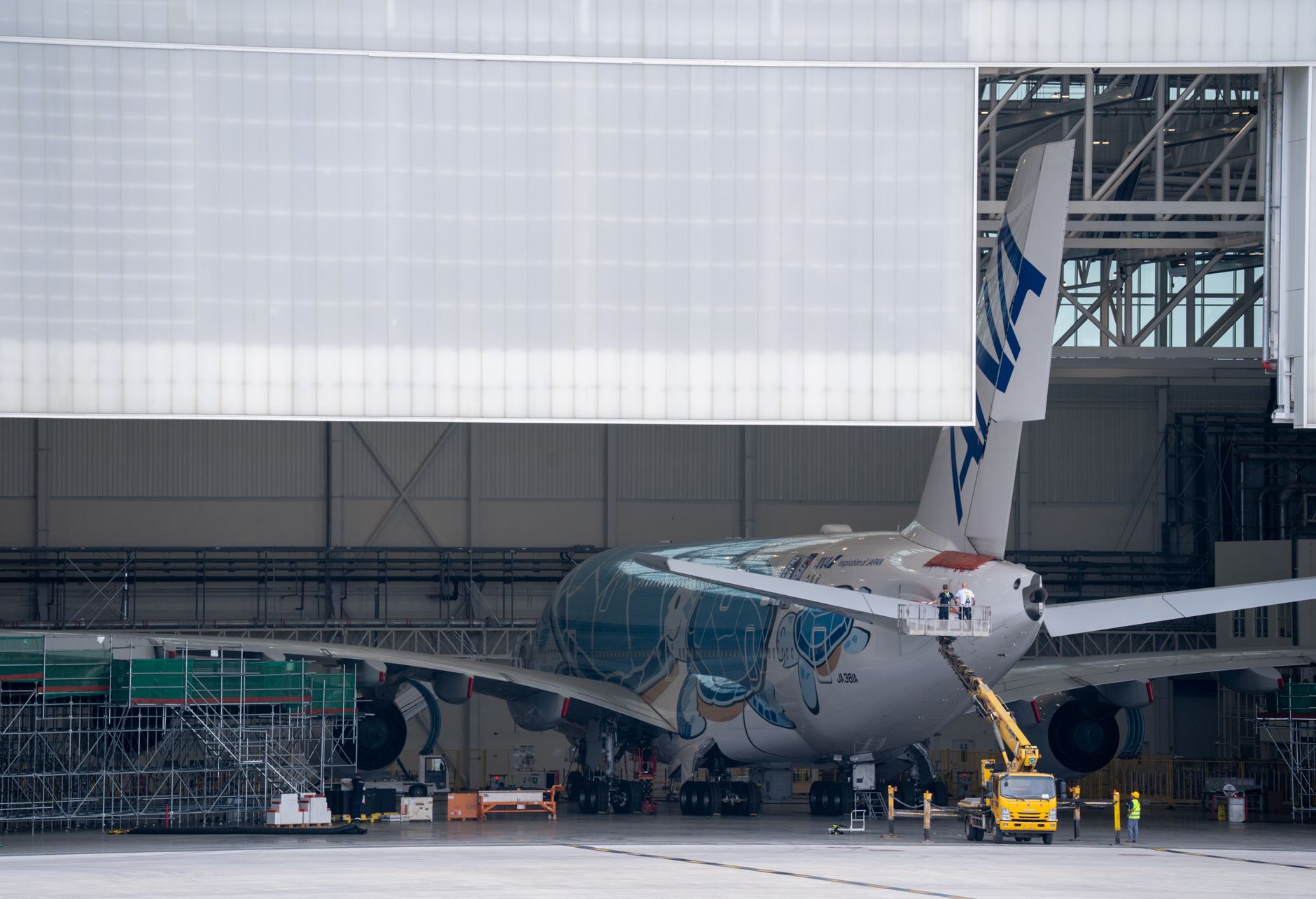 A large aircraft undergoing maintenance in a hangar, showcasing aviation industry operations.