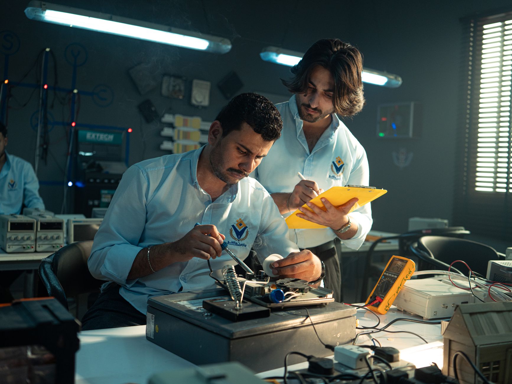 Focused technicians collaborate in an electronics lab, emphasizing teamwork and innovation.