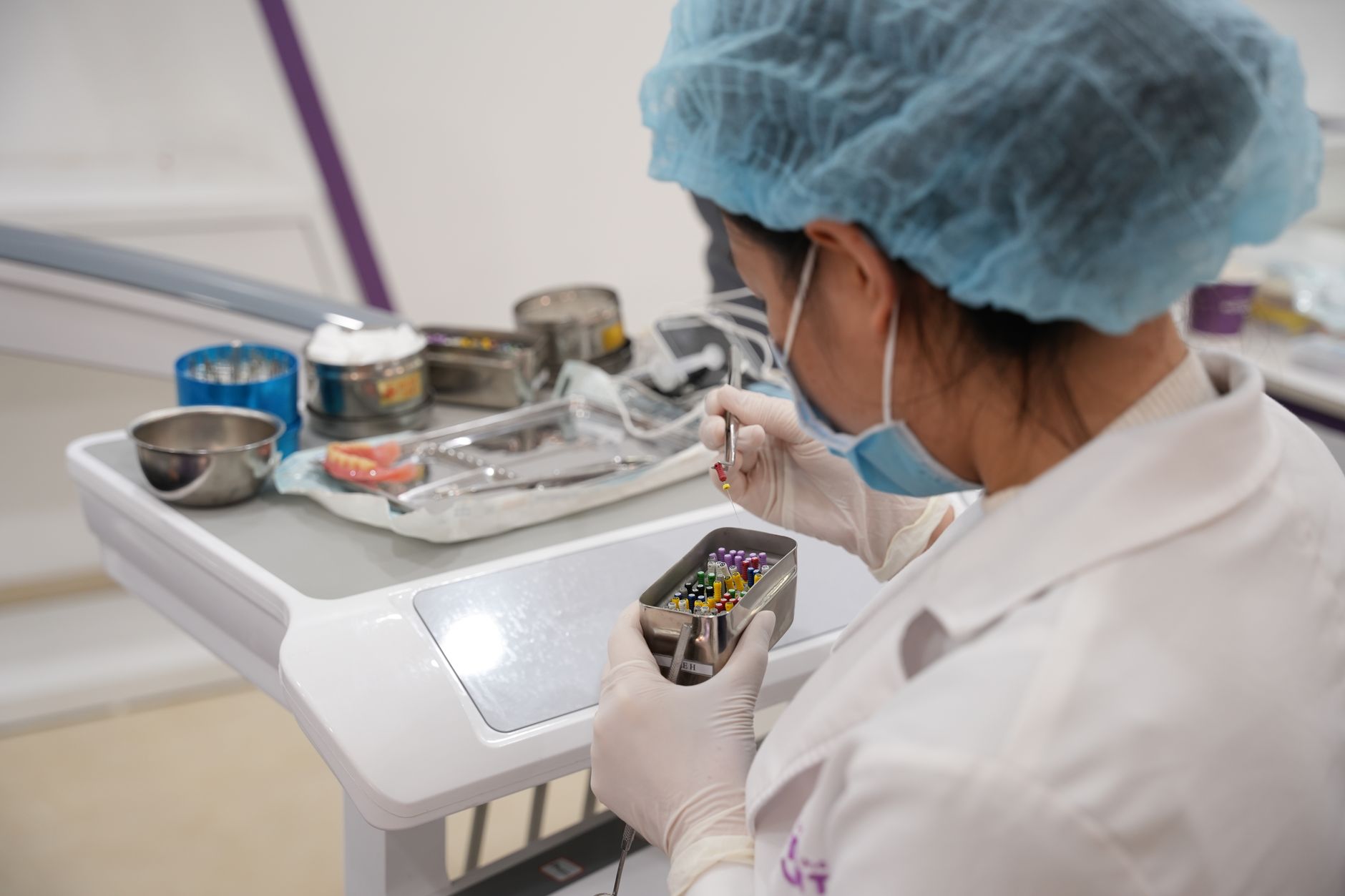 A laboratory technician wearing protective gear organizes sample tubes in a clinical setting.
