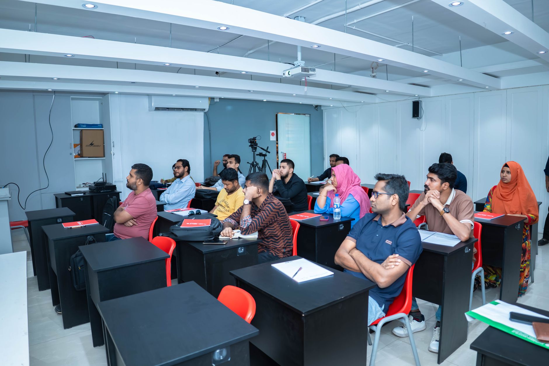 Students attentively listening to a lecture in a modern classroom setting.