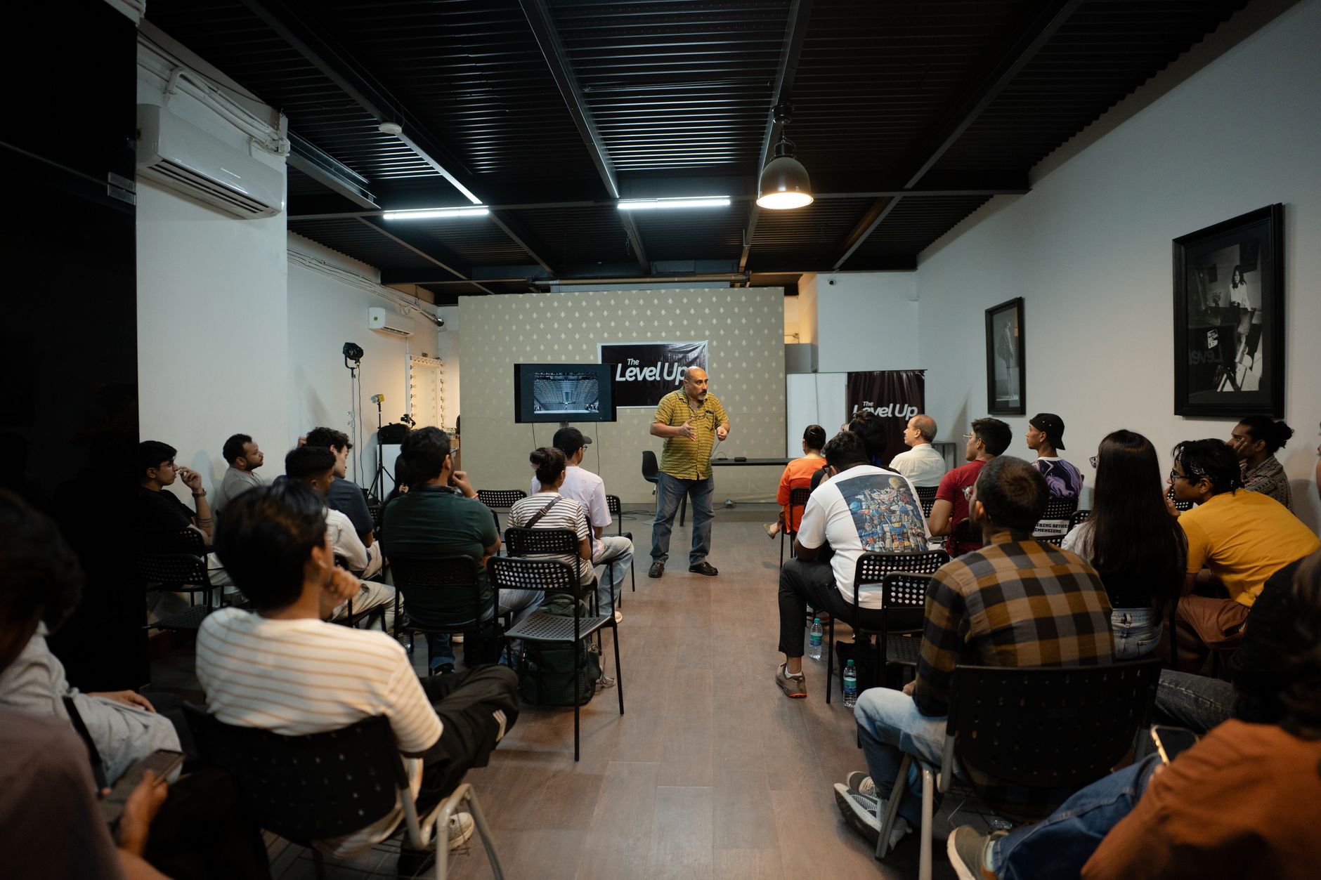A professional giving a lecture to a group in a modern indoor workshop setting.